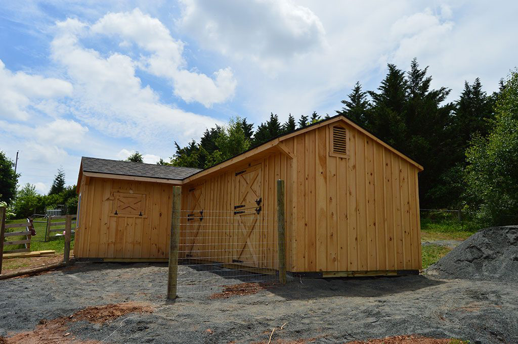 A wooden shed row barn with open stall fronts