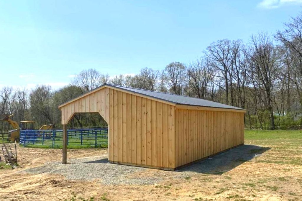 small wood l shaped shed row barn on farm